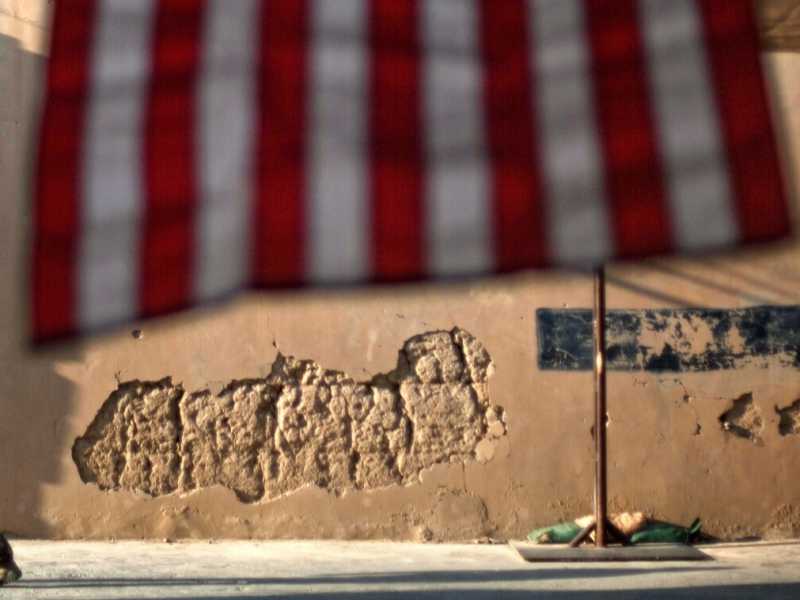 Afghanistan, 11 settembre 2011. Un soldato americano davanti a una bandiera appesa per la cerimonia commemorativa del decimo anniversario dell'attentato (Foto AP / David Goldman, File)