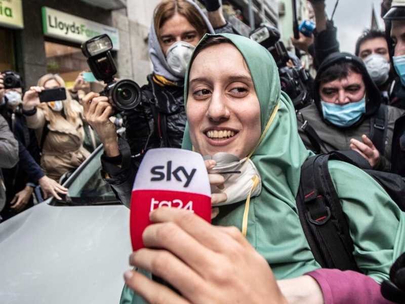Silvia Romano circondata da giornalisti e fotografi davanti alla sua casa di Milano (foto LaPresse)