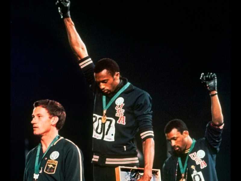 Tommie Smith (primo classificato) e John Carlos (terzo) alzano il pugno guantato sul podio dei 200 metri alle Olimpiadi di Messico '68 (foto LaPresse)