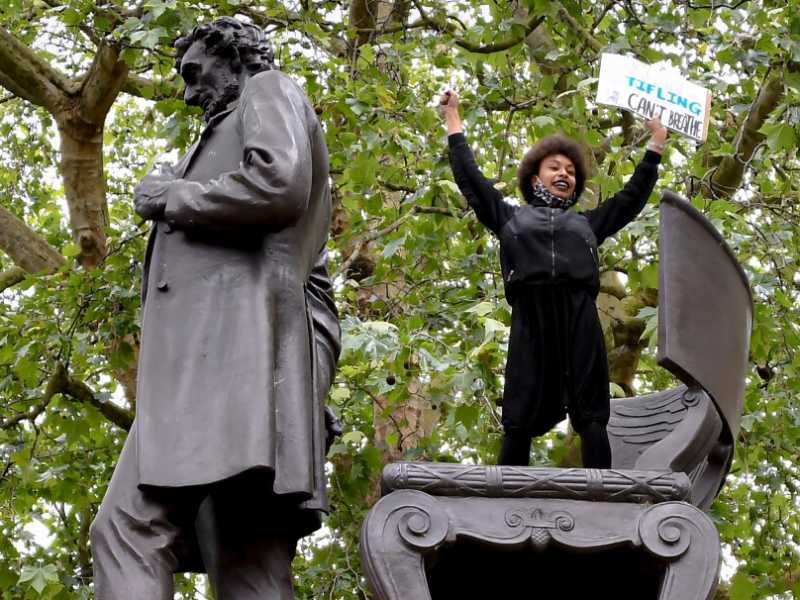Una manifestante del movimento Black Lives Matter sulla statua di Lincoln a Londra (foto LaPresse)