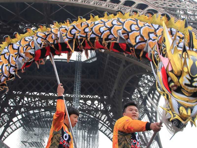 Membri della comunit&agrave; cinese, ballano con costumi per celebrare il capodanno cinese alla Torre Eiffel a Parigi, sabato 25 gennaio 2020 (Foto AP / Michel Euler)