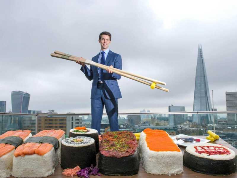 Edward Hopkins posa con il pi&ugrave; grande sushi del mondo di fronte allo skyline di Londra (foto LaPresse)