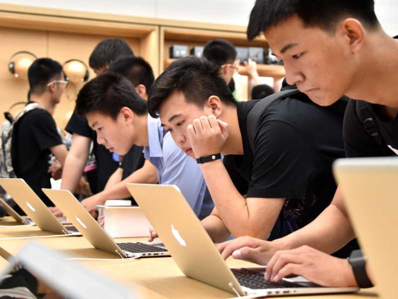Alcuni utenti testano un nuovo computer Apple in Cina (foto LaPresse)
