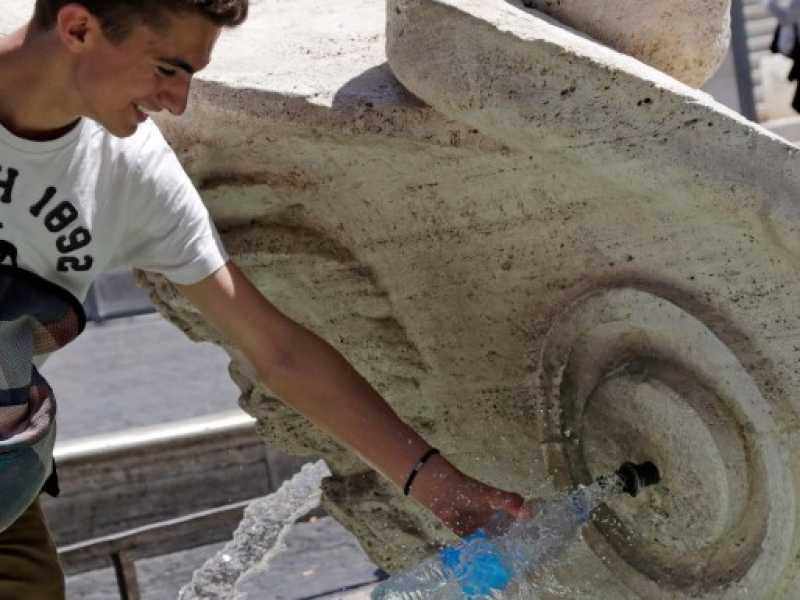 I turisti cercano refrigerio nelle fontane di Roma (foto LaPresse)