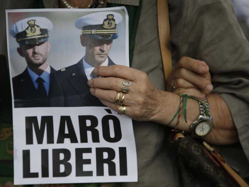 Una donna tiene in mano un volantino per la liberazione dei due marò detenuti in India (Foto Lapresse)
