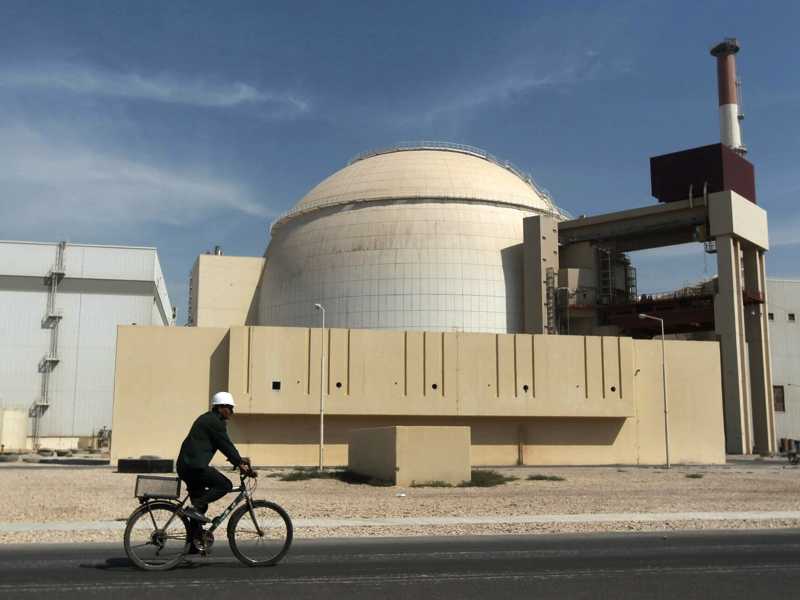 un operaio va in bicicletta davanti all'edificio del reattore della centrale nucleare di Bushehr (AP Photo / Mehr News Agency)&nbsp;<br />
