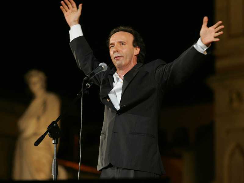 Roberto Benigni mentre recita Dante sotto la statua del poeta in piazza Santa Croce a Firenze, nel 2006 (MAURIZIO DEGLI INNOCENTI ANSA-CD) <br />