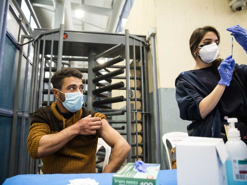 Un palestinese che lavora in Israele riceve la prima dose di vaccino Moderna al checkpoint con la Cisgiordania, 9 marzo 2021 (foto di Amir Levy / Getty Images)&nbsp;<br />