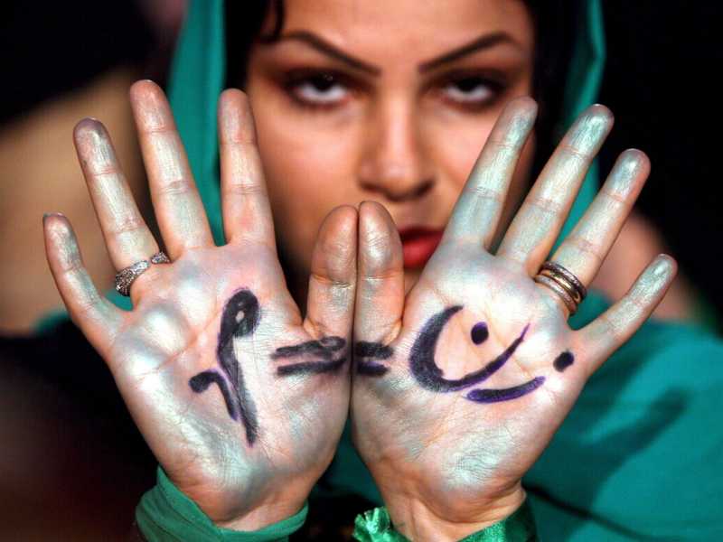 Una donna iraniana durante una manifestazione a Teheran mostra i palmi delle mani con la scritta &ldquo;zan (donna) = mard (uomo)&rdquo;. (Ansa)&nbsp;<br />