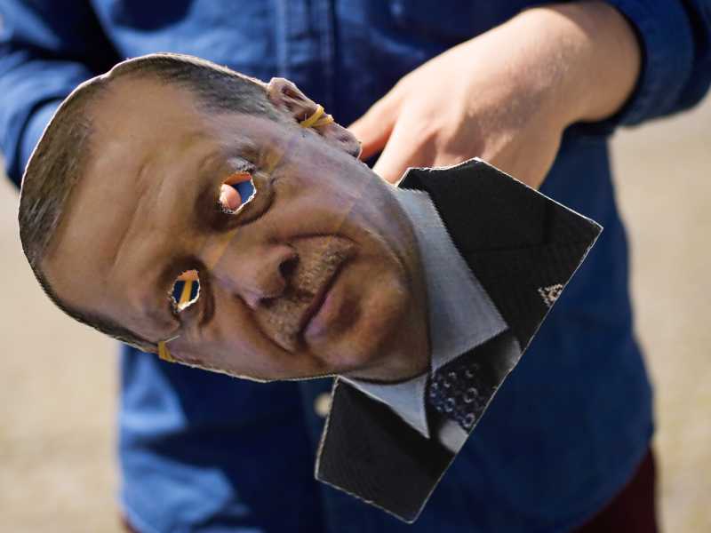 Un manifestante con la maschera del presidente turco Erdogan, durante una manifestazione contro la Nato a Bruxelles (LaPresse)