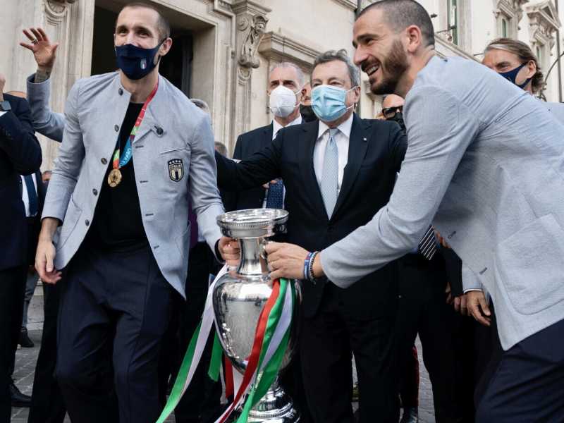 <span style="font-family: Arial, Verdana, sans-serif; font-size: 12px;">Mario Draghi con Giorgio Chiellini, Leonardo Bonucci e il trofeo di Euro 2020 (Ansa)</span>