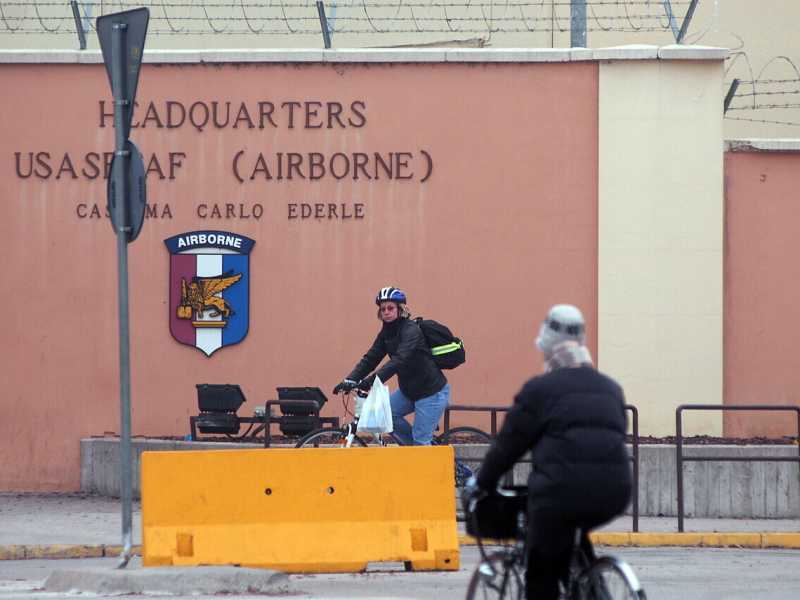 In bicicletta di fronte all'ingresso della Caserma Carlo Ederle in viale della Pace a Vicenza (Ansa, Andrea Merola) <br />