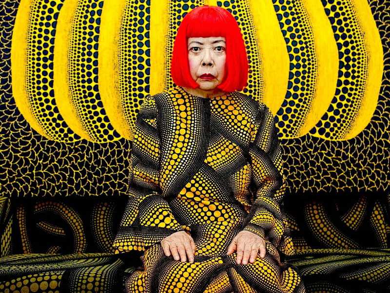 Ritratto di Yayoi Kusama davanti a uno dei suoi dipinti di zucche. Foto: Noriko Takasugi