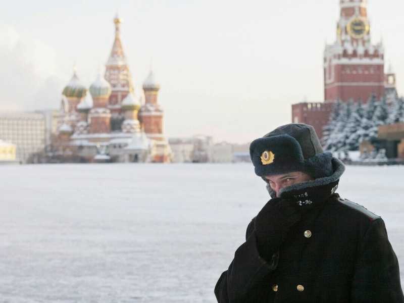 MOSCOW - JANUARY 7: A Russian police officer, braving the bitter cold, patrols Red Square with the Kremlin in the background January 7, 2003 in Moscow <br />