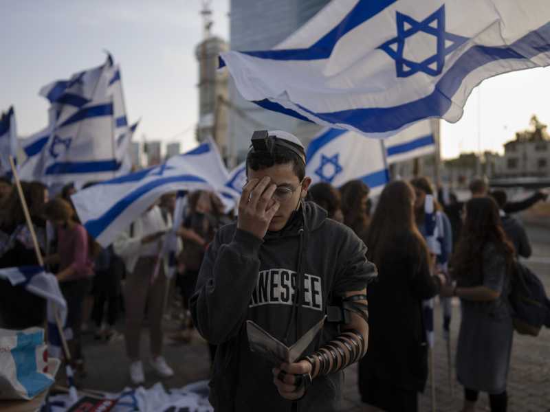 Un giovane prega durante una protesta a Tel Aviv contro il governo Bennett dopo una serie di attentati in tutto il paese (foto LaPresse)