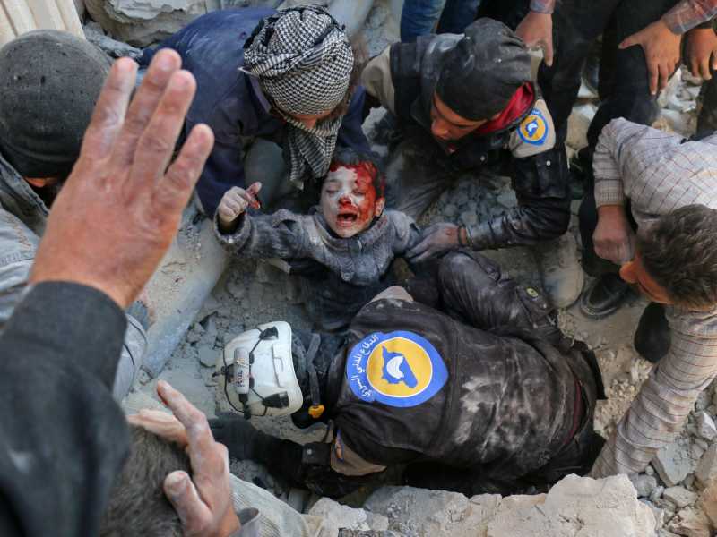 I volontari dei White Helmets salvano un bambino dalle macerie dopo un bombardamento vicino ad Aleppo (foto al Halbi, Afp, WordPress)<br />