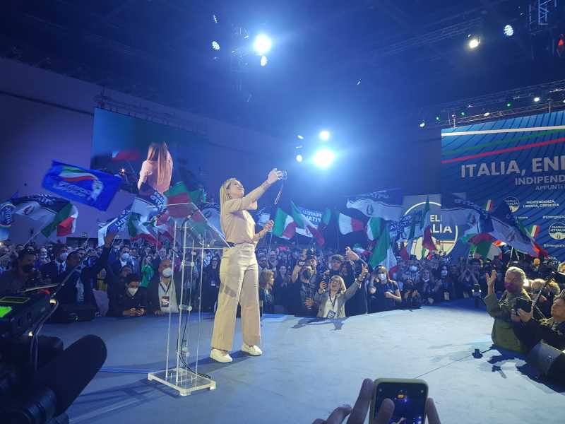 L'assalto di Meloni al centrodestra con le maschere di Gigi Proietti e Beppe Grillo
