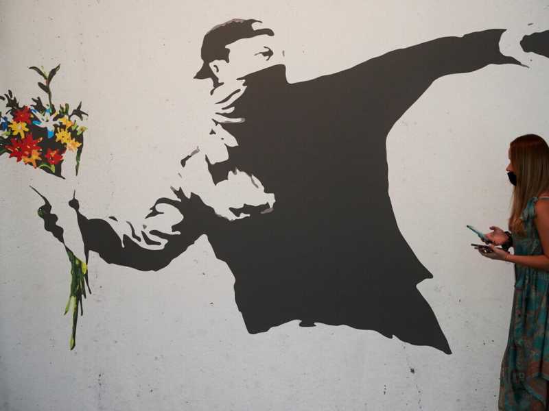 "Lanciatore di fiori", una delle pi&ugrave; famose opere di&nbsp; Banksy (Foto Ansa)