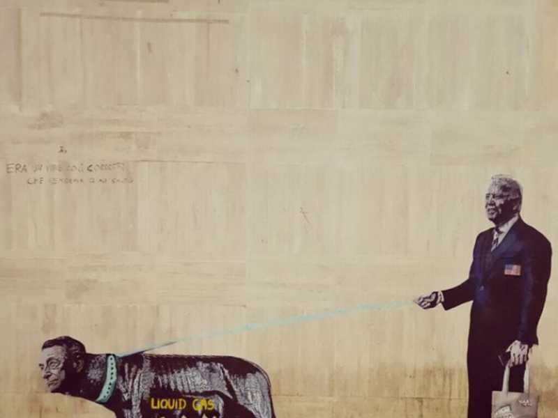 Il tesoriere M5s condivide il murales con Draghi al guinzaglio di Biden