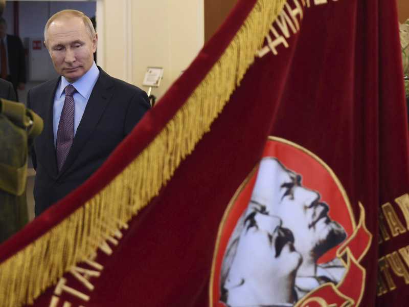Putin guarda uno striscione dell'era sovietica con Lenin e Stalin, nel 2020 (foto Alexei Nikolsky, Sputnik via AP)<br />