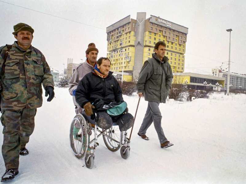 Veterani della guerra in Bosnia sulla famigerata &ldquo;Sniper Alley&rdquo;, la via dei cecchini davanti all&rsquo;Holiday Inn di Sarajevo, 1994 (AP Photo/Rikard Larma)&nbsp;<br />