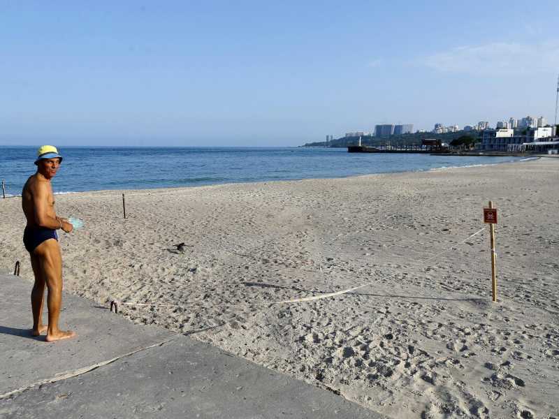 Un uomo davanti a una spiaggia chiusa a Odessa (foto di Ansa)