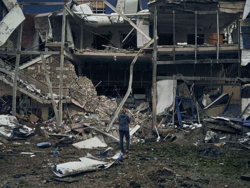 Una donna di fronte a un edificio distrutto a causa dei bombardamenti russi (AP Photo/Kostiantyn Liberov)<br />