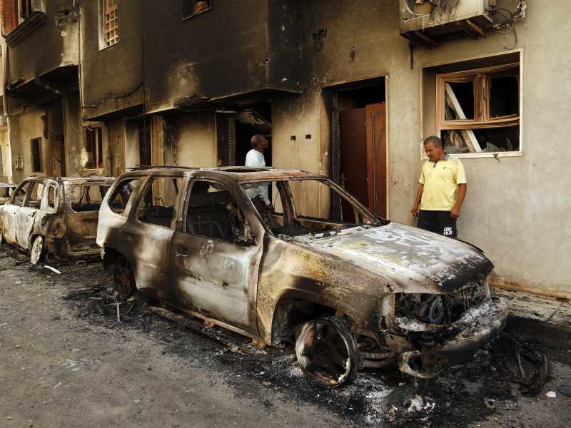 I resti di un'automobile in fiamme domenica a Tripoli (foto: AP Photo/Yousef Murad)<br />