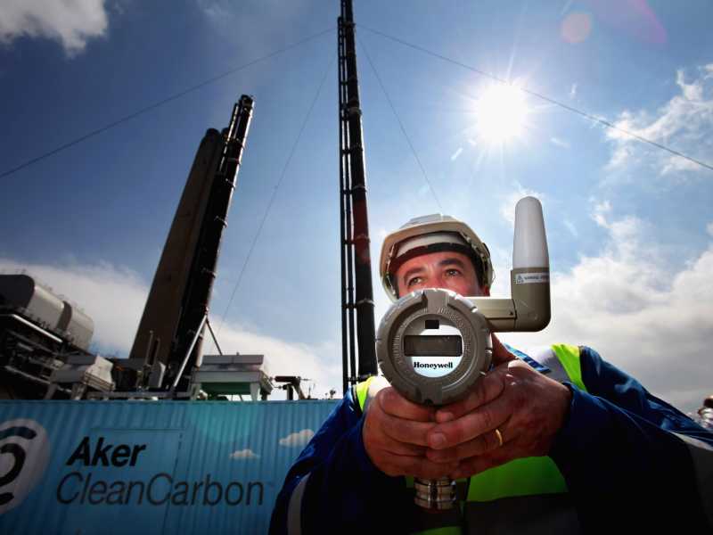 Uno scienziato con un monitor di pressione, accanto a una nuova unit&agrave; di test per la cattura del carbonio in Scozia (Foto di Jeff J Mitchell/Getty Images)&nbsp;<br />
