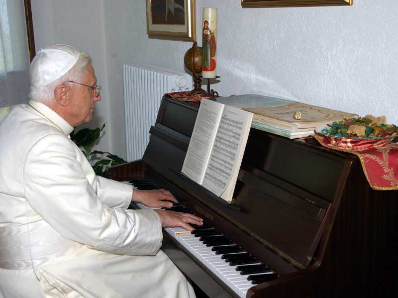 Papa Benedetto XVI al pianoforte con gli amati spartiti di Bach e Mozart (Ansa)&nbsp;<br />