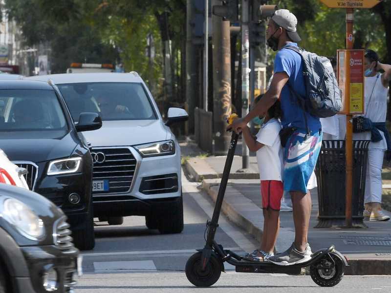 Una persona su un monopattino elettrico in una delle ve del centro (Ansa)