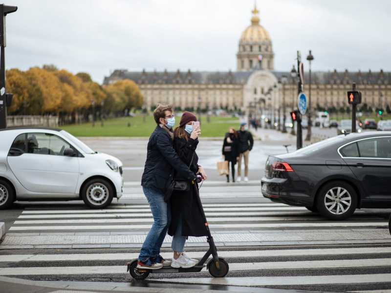 Una coppia in monopattino si scatta una foto davanti all’Hotel des Invalides (AP Photo/Lewis Joly) <br />