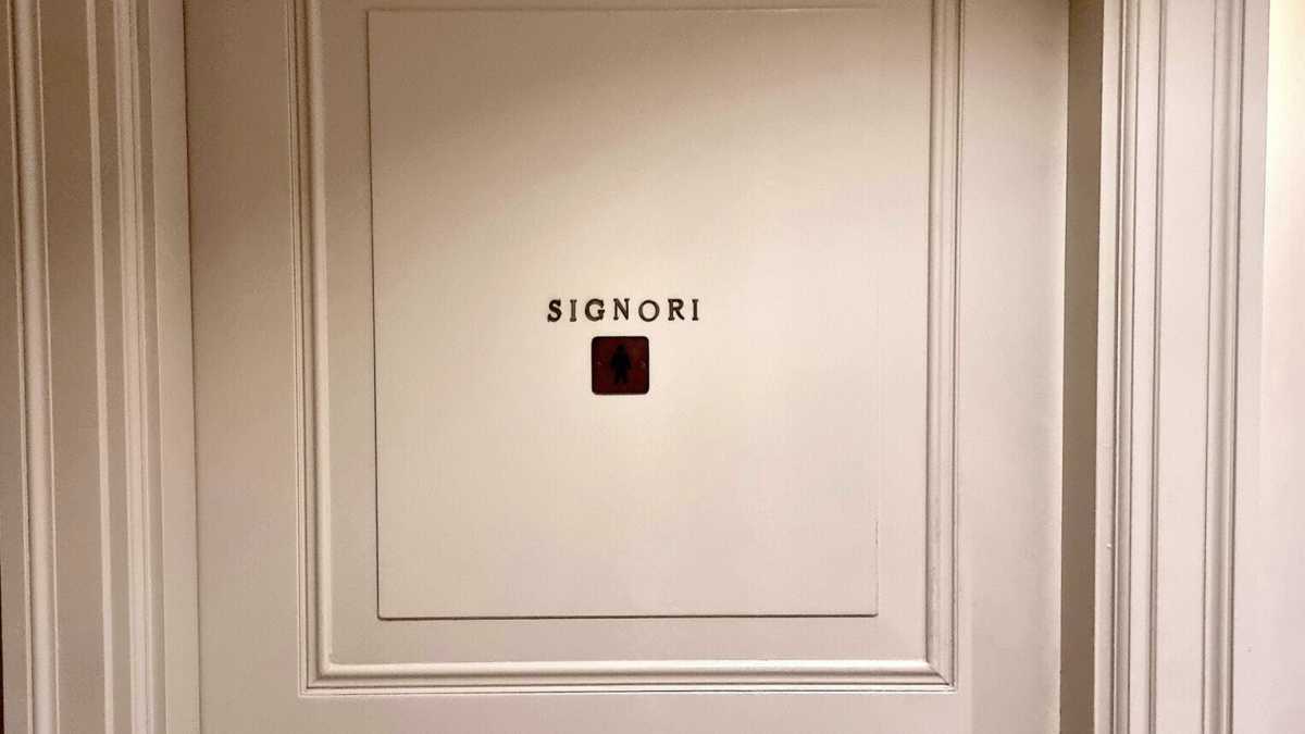 Immagine di Un segno di speranza: la porta di un bagno con scritto "Signori"