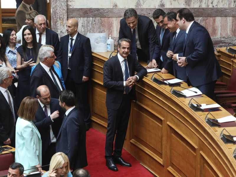  Il primo ministro greco Kyriakos Mitsotakis circondato da parlamentari (Ansa)<br />