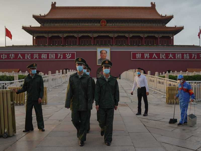 Due agenti cinesi marciano attraverso la porta di Tiananmen (Foto di Lintao Zhang/Getty Images) <br />