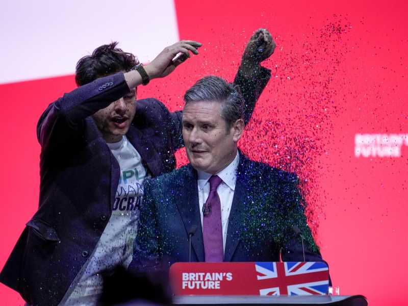 Un manifestante fa irruzione sul palco e lancia glitter sul leader del partito laburista, Keir Starmer (Christopher Furlong/Getty Images)&nbsp;<br />