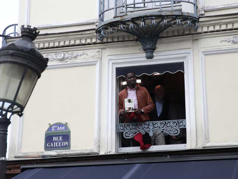 Il senegalese Mohamed Mbougar Sarr al balcone del ristorante Drouant subito dopo aver vinto il premio Goncourt edizione 2021 (foto LaPresse)&nbsp;<br />
