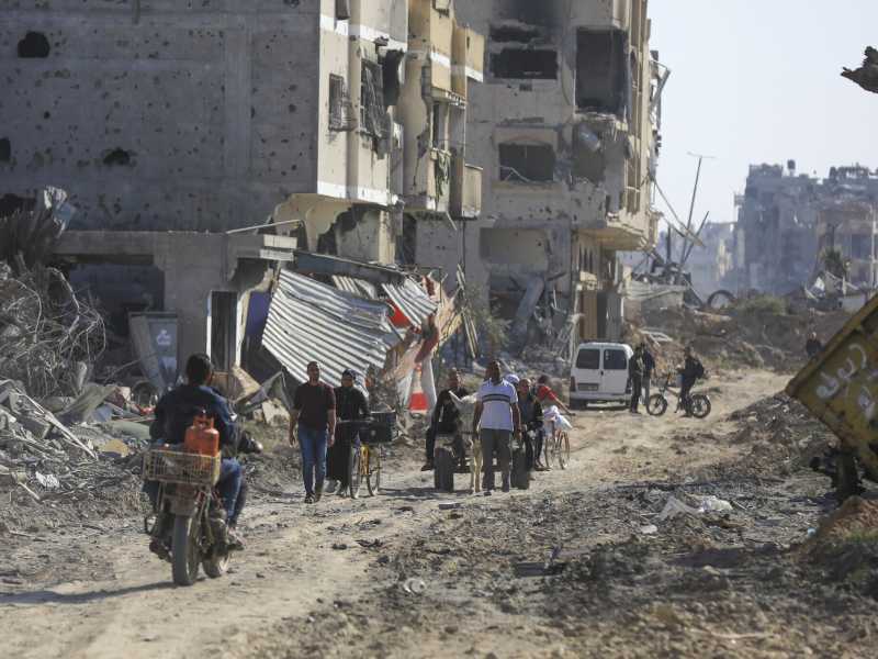 Palestinesi in mezzo alle macerie lasciate dall’offensiva aerea e terrestre israeliana a Khan Younis (AP Photo/Ismael Abu Dayyah) <br />