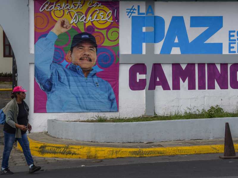Una donna cammina davanti a un cartellone con una foto del presidente nicaraguense Daniel Ortega a Managua (Getty Images)&nbsp;<br />