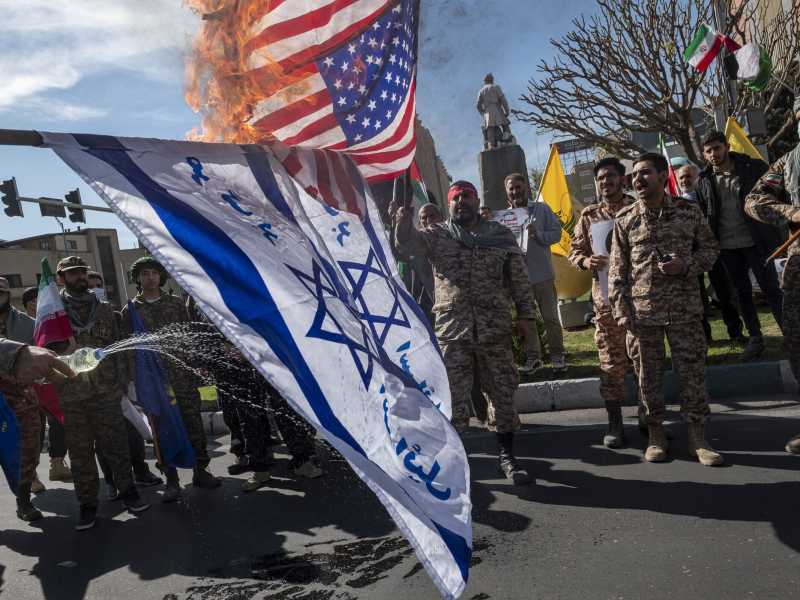 Guardie della Rivoluzione bruciano bandiere di Israele e degli Stati Uniti a Teheran, Iran, nell'aprile 2024 (Morteza Nikoubazl/Getty Images)&nbsp;<br />