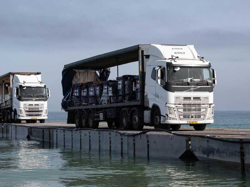 Alcuni camion attraversano il ponte galleggiante a Gaza (foto LaPresse)