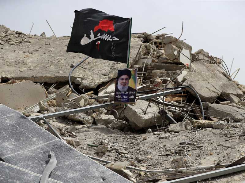 Una foto del leader di Hezbollah Hassan Nasrallah tra le macerie di un edificio distrutto da un attacco israeliano nel sud del Liban (AP/Mohammad Zaatari)&nbsp;<br />