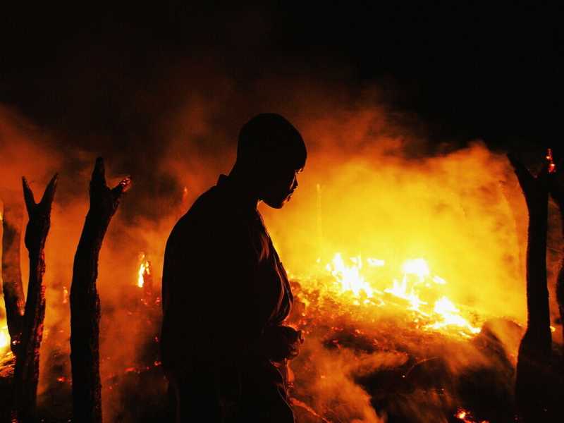Un combattente ribelle sudanese osserva il villaggio abbandonato di Chero Kasi bruciare (Foto di Scott Nelson/Getty Images)&nbsp;<br />