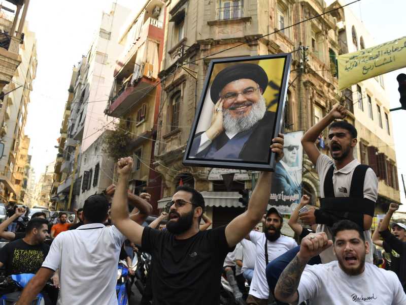 Beirut, un gruppo di uomini si è radunato per le strade sotto l'effigie di Nasrallah (Foto di Houssam Shbaro/Anadolu tramite Getty Images) <br />