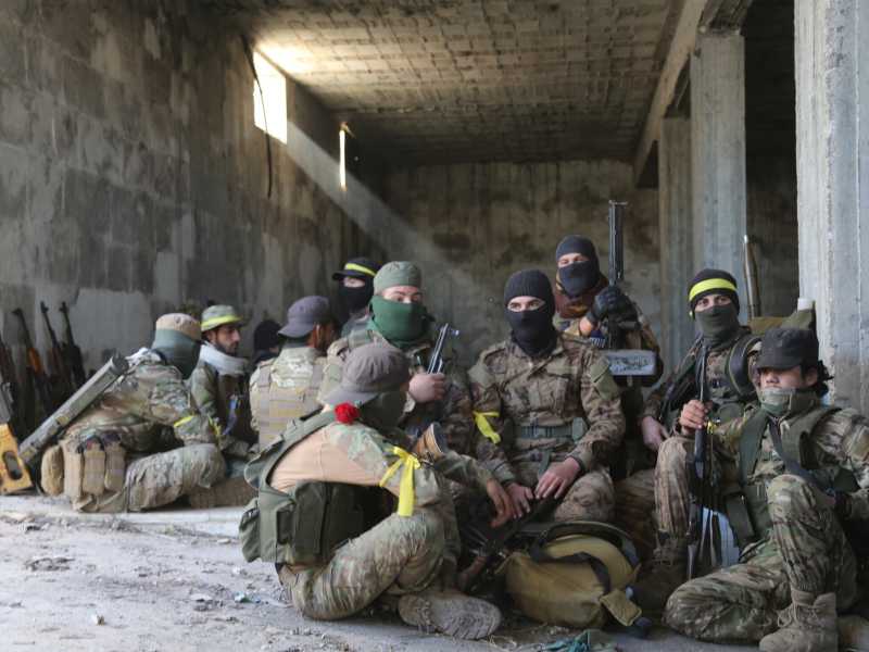 Un gruppo di combattenti di Hts si riposano durante i combattimenti verso Aleppo (foto Getty)