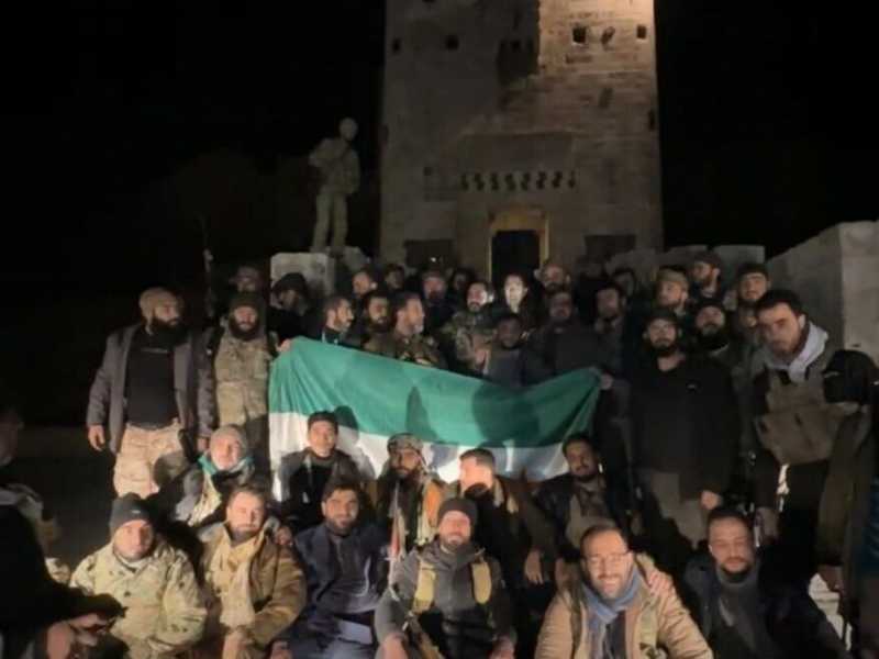  I ribelli posano per una foto davanti alla Cittadella di Aleppo liberata dal regime 