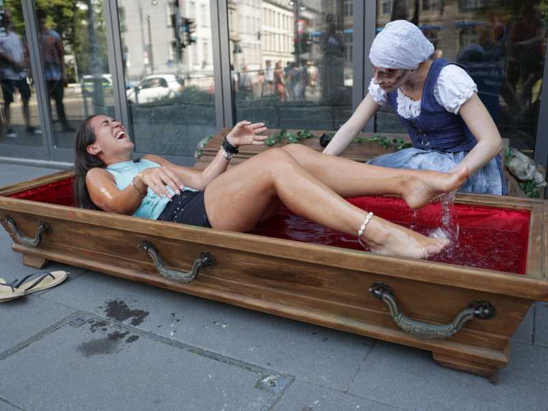 Una donna in una bara piena di acqua ghiaccio di fronte al Berlin Dungeon, attrazione a tema horror nella capitale tedesca (J&ouml;rg Carstensen/Getty Images)&nbsp;<br />