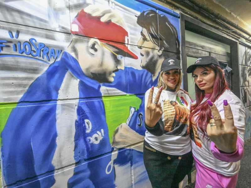Fan di Geolier davanti al murales del musicista benedetto da Maradona (Ansa) 