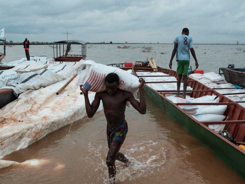 Luglio 2023, un giovane trasporta un sacco di sorgo dell'USAID in un campo per sfollati a Bentiu, nel Sudan del Sud (GettyImages)&nbsp;<br />