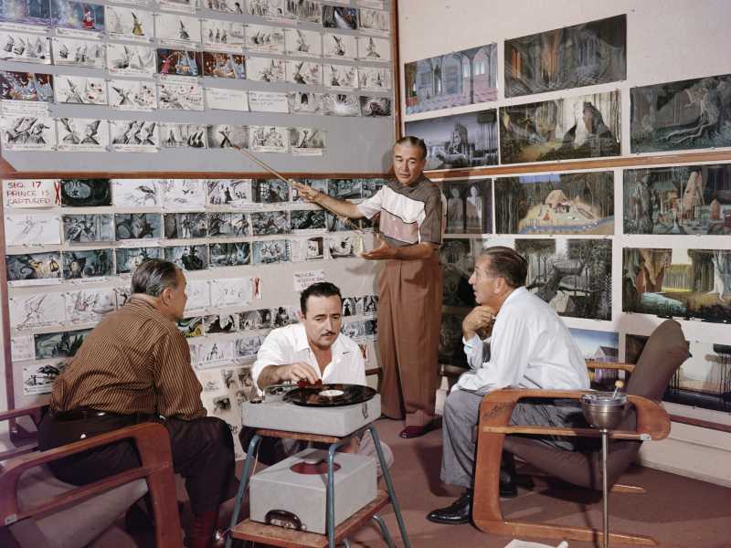 Walt Disney (a destra) ascolta un animatore parlare degli storyboard di “La bella addormentata” mentre Les Clark fa suonare un disco (Foto Getty)